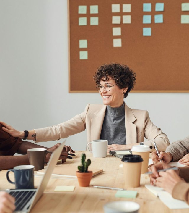 Business professionals engaged in a collaborative meeting in a modern office setting, sharing ideas and smiling.