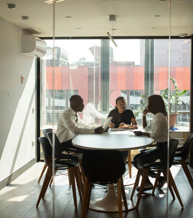 Business professionals in a modern office meeting room collaborating on projects.